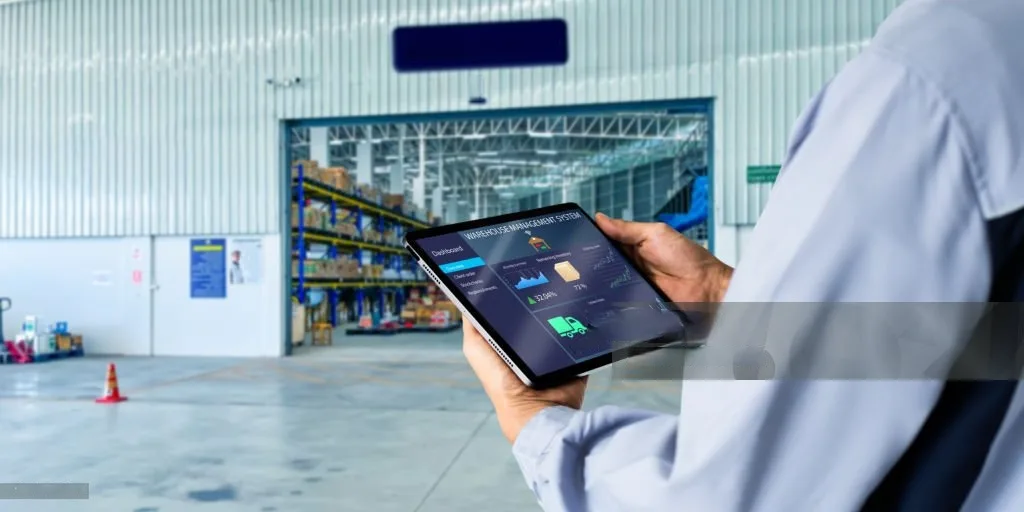 Manajer operasional meninjau data melalui tablet di gudang